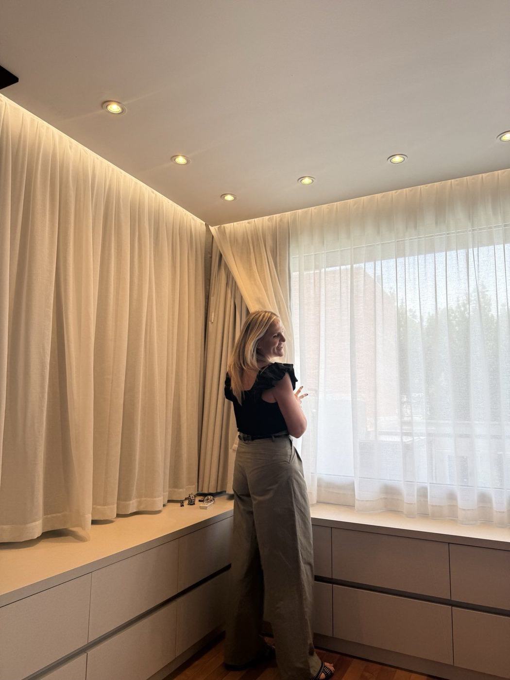 Luisina acomodando las cortinas con luz