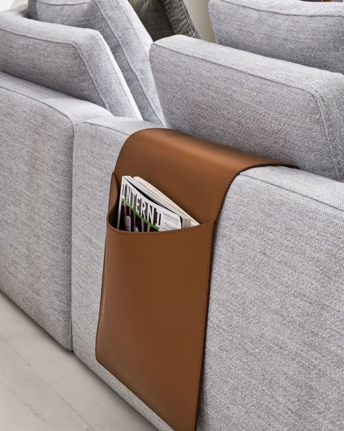 Organizador de cuero suela sobre el brazo de un sillón gris